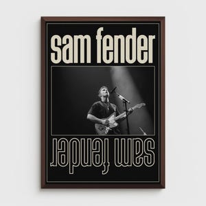 Puede incluir: Un p&oacute;ster en blanco y negro enmarcado con el texto "Sam Fender" en una fuente serif en negrita. El p&oacute;ster incluye una fotograf&iacute;a de un m&uacute;sico tocando la guitarra en el escenario, con el nombre "Sam Fender" repetido en un dise&ntilde;o espejado.
