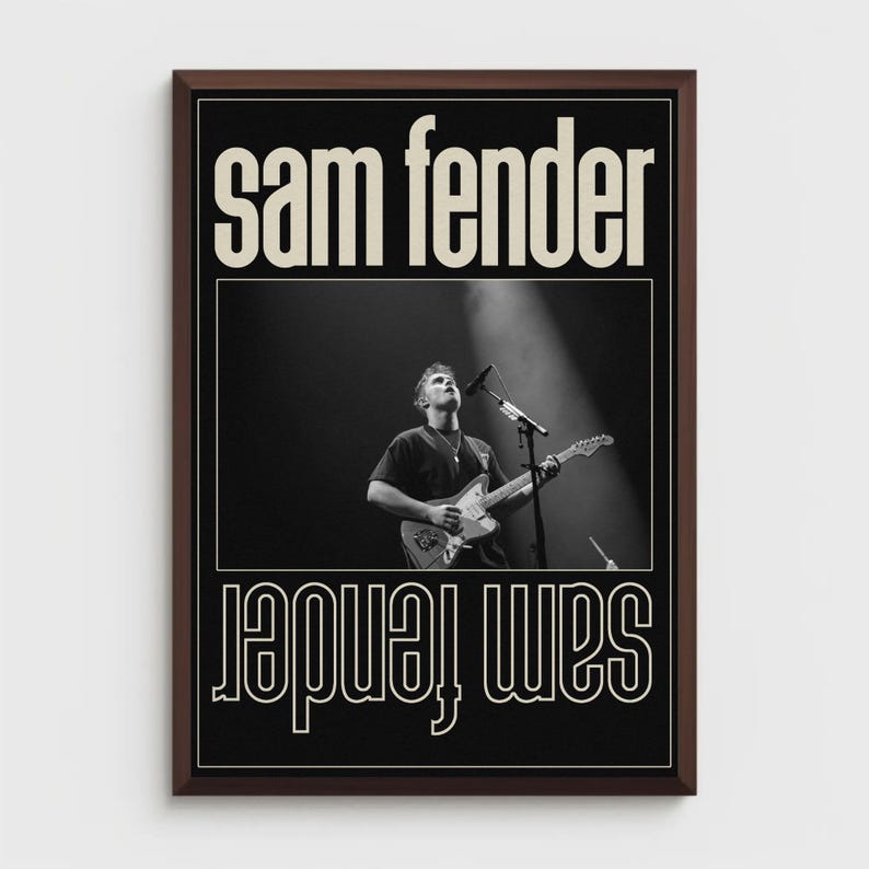 Puede incluir: Un p&oacute;ster en blanco y negro enmarcado con el texto "Sam Fender" en una fuente serif en negrita. El p&oacute;ster incluye una fotograf&iacute;a de un m&uacute;sico tocando la guitarra en el escenario, con el nombre "Sam Fender" repetido en un dise&ntilde;o espejado.
