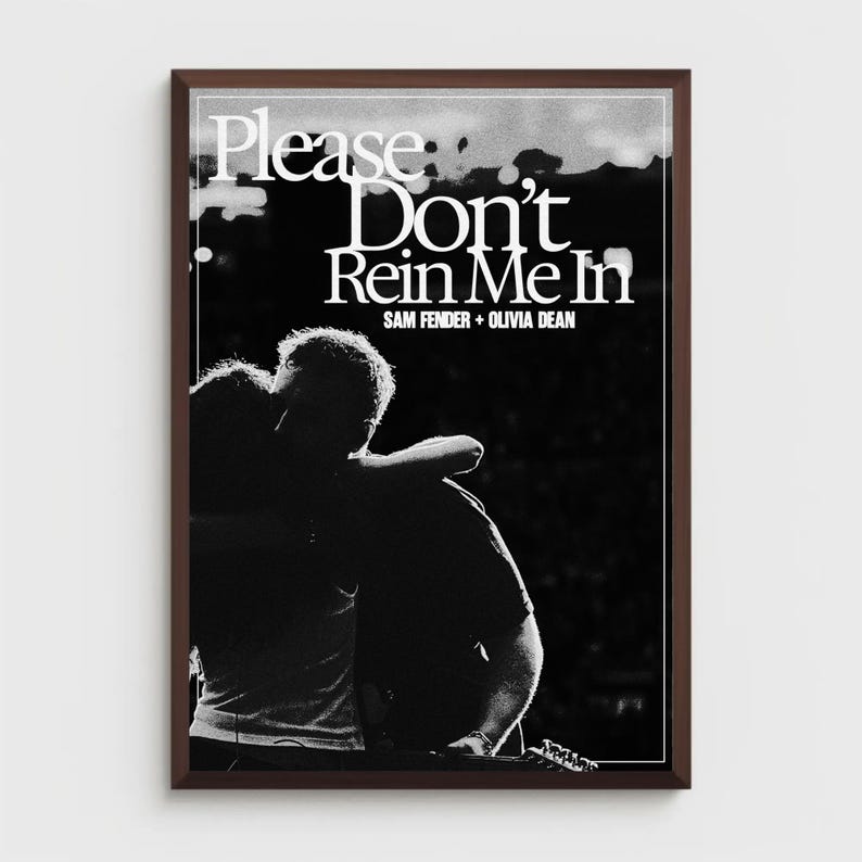 Puede incluir: Un estampado en blanco y negro enmarcado con el texto "Please Don't Rein Me In" y los nombres "SAM FENDER + OLIVIA DEAN". La imagen muestra a dos personas abraz&aacute;ndose. El estampado est&aacute; en un marco marr&oacute;n oscuro.