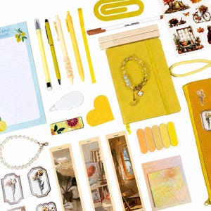 May include: A collection of yellow-themed stationery and accessories including a notebook, pens, a beaded bracelet, bookmarks, stickers, sticky notes, a paperclip, and a pencil case. The items feature various floral and autumn-themed illustrations.