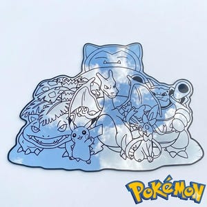 May include: A black and white illustration of various Pok&eacute;mon characters, including Pikachu, Charizard, and Snorlax. The image has a reflective surface, with the Pok&eacute;mon logo in the bottom right corner.
