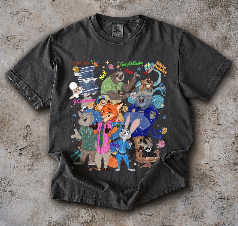 Op de afbeelding: Donkergrijs t-shirt met een kleurrijke cartoonillustratie van verschillende dierenfiguren. Het ontwerp bevat personages als een vos, konijn, luiaard en anderen, met tekstlabels. Het shirt is gemaakt van een zacht materiaal.