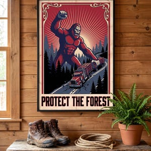 May include: A framed poster featuring a large, muscular Bigfoot creature standing over a red logging truck on a winding road through a dark forest. The background has a red sunburst design, and the text at the bottom reads PROTECT THE FOREST.