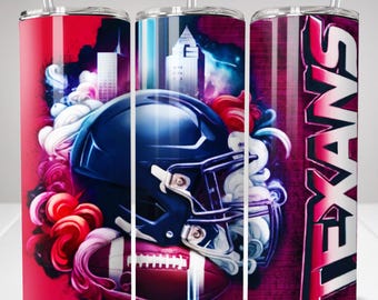 May include: A cylindrical tumbler with a clear straw featuring a dark blue football helmet, a brown football, and a city skyline graphic. The design includes swirling red and white smoke patterns and the word TEXANS in bold white vertical lettering.
