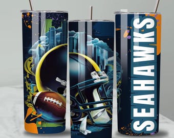 May include: Three cylindrical tumblers with metal straws featuring a dark blue background, a football helmet, a brown football, and a city skyline graphic. The right tumbler displays the word SEAHAWKS in large white vertical letters with orange accents.