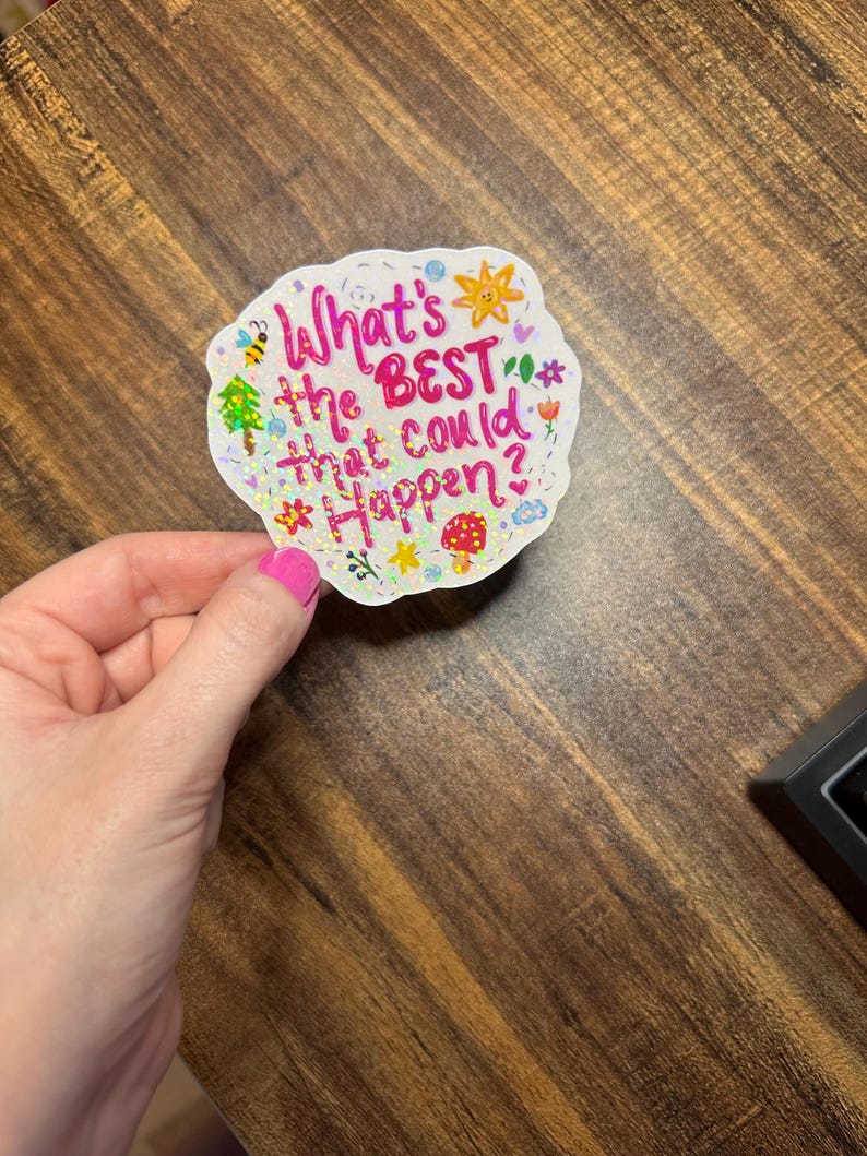 May include: A die-cut sticker with a holographic finish featuring the pink text "What's the BEST that could happen?" surrounded by small colourful illustrations of a sun, a bee, a mushroom, flowers, and stars on a white background.