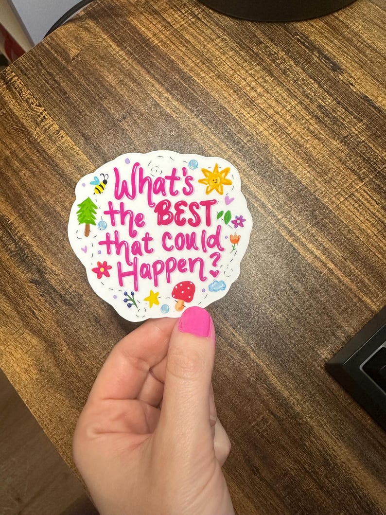 May include: A white die-cut sticker with a scalloped edge featuring the pink text What's the BEST that could Happen? surrounded by colourful illustrations of a bee, a sun, a green tree, a red mushroom, a blue cloud, and various small flowers.