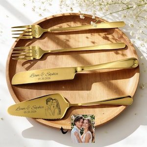 Könnte beinhalten: Eine weiße Keramik-Tasse mit schwarzem Henkel und dem Text "But First, Coffee" in fetter, schwarzer Schrift. Die Tasse steht vor einem verschwommenen Hintergrund, der eine gemütliche Umgebung suggeriert.