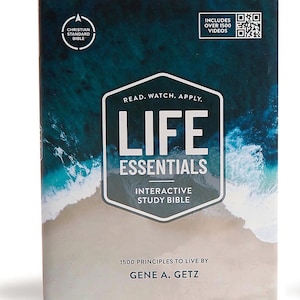 May include: A hardcover book titled "Life Essentials Interactive Study Bible" with a coastal design. The cover features the text "Read. Watch. Apply." and "1500 Principles to Live By." Includes over 1500 videos. The book is a Christian Standard Bible.
