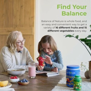 Op de afbeelding: Een vrouw en een jong meisje glimlachen terwijl ze een rode fles met een fruitontwerp vasthouden. De tekst "Find Your Balance" staat bovenaan, met tekst eronder waarin staat dat het product 16 soorten fruit en 15 soorten groenten bevat.