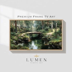 May include: A framed landscape painting of a serene forest scene with a small stone bridge over a calm river. The artwork features lush greenery, tall trees, and the text "PREMIUM FRAME TV ART" and "LUMEN SCREEN ART".