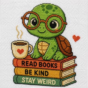 Op de afbeelding: Kruissteekontwerp van een groene schildpad met een bril, zittend op een stapel boeken. De boeken lezen "Read Books, Be Kind, Stay Weird". Een kopje koffie met een hart en een klein hartje staan ook in de afbeelding.