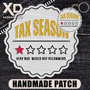May include: Embroidered patch with the words "TAX SEASON" in gold thread. Features a red star, four outlined stars, and the phrase "VERY BAD WOULD NOT RECOMMEND." A smaller keychain version repeats the design. The patch is labeled "HANDMADE PATCH."