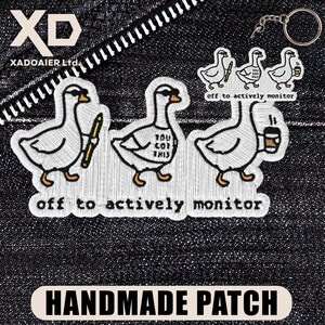 May include: Embroidered patches of cartoon geese wearing sunglasses, holding a pen, with the text "You Got This", and a coffee cup. The patches are on a dark denim background with the text "off to actively monitor" and "HANDMADE PATCH".