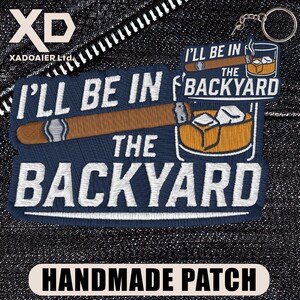 May include: Embroidered patch with the text "I'll Be In The Backyard" and a cigar illustration. A smaller keychain patch shows a whiskey glass and cigar. The patches are navy blue with white and brown details. The bottom patch reads "HANDMADE PATCH".