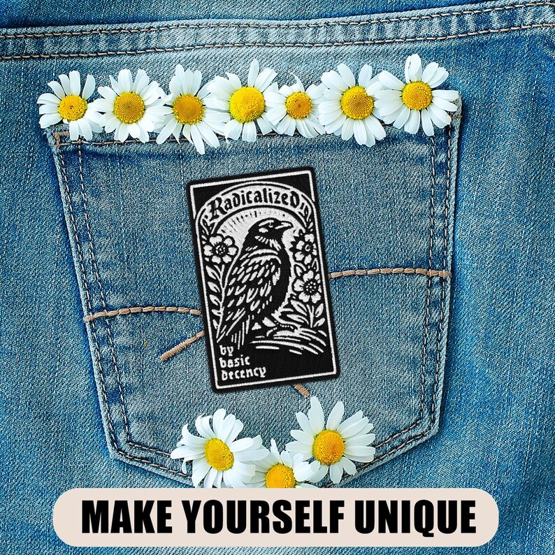 May include: A denim pocket adorned with daisies and a black patch featuring a raven illustration and the text "Radicalized by basic decency." The phrase "MAKE YOURSELF UNIQUE" is displayed at the bottom.