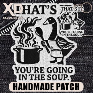 May include: Embroidered patch featuring a cartoon goose wearing an apron and holding a spoon, with a pot of soup. Text reads "YOU'RE GOING IN THE SOUP" and "HANDMADE PATCH". The design is in black and white.