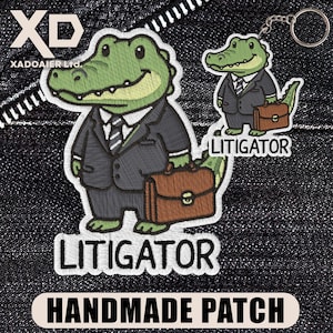 May include: An embroidered patch and a matching keychain featuring a green alligator wearing a dark grey suit, white shirt, and striped tie, while holding a brown briefcase. Both items display the text LITIGATOR in bold black capital letters.