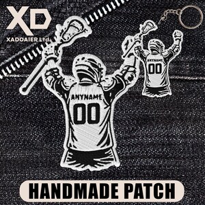 May include: Embroidered patch and keychain featuring a lacrosse player in a uniform with the text "ANYNAME" and the number "00". The patch and keychain are white and black. The image also includes the text "HANDMADE PATCH".