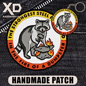 May include: Embroidered patch and keychain featuring a raccoon with a hammer, working on an anvil over flames. The patch and keychain have the text "In the fire of a dumpster, the strongest steel is forged." The patch also says "Handmade Patch".