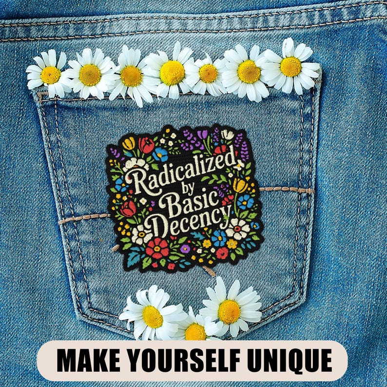 May include: A denim pocket adorned with daisies and a floral patch that reads "Radicalized by Basic Decency." The phrase "MAKE YOURSELF UNIQUE" is at the bottom. The patch features colorful flowers and foliage.