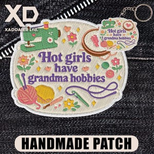 May include: Embroidered patch with the text "Hot girls have grandma hobbies" and a matching keychain. The patch features a sewing machine, yarn, flowers, and a needle. The keychain has the same text and a sewing machine.