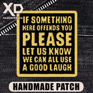 May include: Black and gold embroidered patch with the text "IF SOMETHING HERE OFFENDS YOU PLEASE LET US KNOW WE CAN ALL USE A GOOD LAUGH." The patch is rectangular with rounded corners and the words "HANDMADE PATCH" at the bottom.