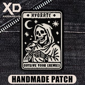 May include: Black and white embroidered patch featuring a skeleton in a hooded robe drinking from a bottle. The patch reads "HYDRATE" at the top and "OUTLIVE YOUR ENEMIES" at the bottom. The patch is labeled "HANDMADE PATCH".