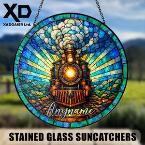 Könnte beinhalten: Runder Glas-Suncatcher mit einem farbenfrohen Zugdesign. Der Suncatcher hat einen schwarzen Metallrahmen und wird von einer Kette gehalten. Der Text "Anymame" ist sichtbar. Der Text "STAINED GLASS SUNCATCHERS" befindet sich unten.