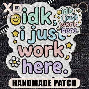 May include: Embroidered patch and keychain with the phrase "idk, i just work here" in pastel colors. The patch features stars, flowers, and a smiling face. The keychain has a silver ring.
