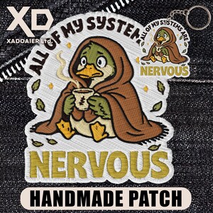 May include: Embroidered patch featuring a cartoon duck in a brown cloak, holding a cup of coffee. Text includes "ALL OF MY SYSTEM" and "NERVOUS". A keychain with a smaller version of the design is also visible. The patch is labeled "HANDMADE PATCH".