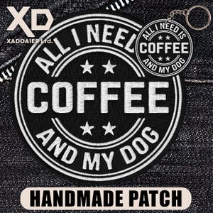May include: A black and white embroidered patch with the text "ALL I NEED IS COFFEE AND MY DOG". The patch has a circular design with stars and the words "HANDMADE PATCH" at the bottom. A matching keychain is also visible.