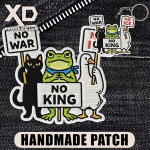 May include: Handmade patch featuring a black cat, a green frog, and a white duck holding signs that read "NO WAR", "NO KING", and "NO ICE". The patch also includes the text "HANDMADE PATCH".
