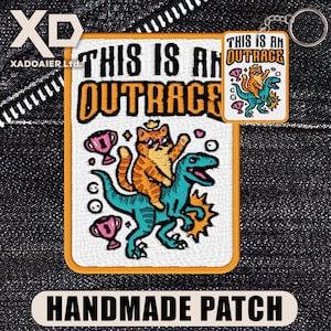 May include: A rectangular embroidered patch and a matching keyring featuring an orange tabby cat wearing sunglasses while riding a teal dinosaur. The design includes pink trophies and the text THIS IS AN OUTRAGE in black and orange lettering.