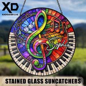 May include: Circular stained glass suncatcher with a vibrant treble clef, musical notes, and piano keys design. The name "Sophia" is written in cursive. It has a black border and is hung by a chain. The text "STAINED GLASS SUNCATCHERS" is at the bottom.