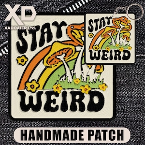 May include: Embroidered patch and keyring set with a whimsical design. The patch and keyring feature a rainbow, mushrooms, and the words "STAY WEIRD" in black. The patch also has the words "HANDMADE PATCH" in a white rectangle.
