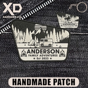 May include: Embroidered black and white patch with a camping design, including a van, tent, trees, and mountains. The text "ANDERSON FAMILY ADVENTURES Est 2023" is present. A keychain version is also shown. The bottom reads "HANDMADE PATCH".