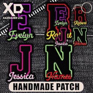 May include: A selection of handmade embroidered patches with letters and names. The patches are black with neon-coloured outlines and text, including "Evelyn," "Robert," "Jessica," and "Names." The text "HANDMADE PATCH" is also visible.