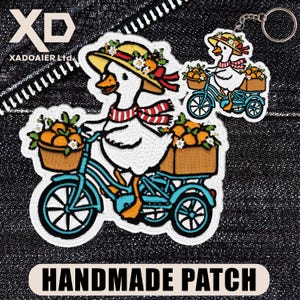 May include: Embroidered patch and keychain featuring a goose riding a blue bicycle, carrying oranges in baskets. The goose wears a hat and scarf. The patch has the text "HANDMADE PATCH".