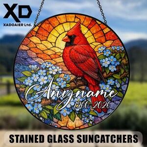 May include: Round stained glass suncatcher featuring a red cardinal perched on a branch with blue flowers. The background has a stained glass design with orange and yellow hues. Text includes "Anyname" and dates.