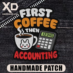 May include: A white ceramic mug with a black handle and the text "But First, Coffee" in a bold, black font. The mug is set against a blurred background, suggesting a cozy setting.