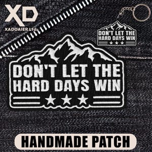 May include: Black and white embroidered patch with the text "DON'T LET THE HARD DAYS WIN" and three stars. A smaller matching keychain is also visible. The patch is labeled "HANDMADE PATCH".