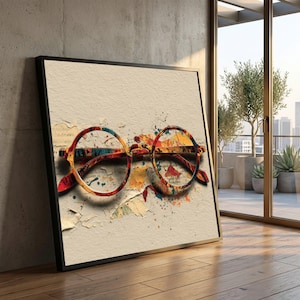 May include: A framed art print showing a vibrant, abstract representation of round spectacles. The glasses are painted with red, yellow, blue, and orange colours, set against a textured, off-white background with paint splatters. The frame is black.