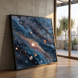 May include: A framed art print with an abstract cosmic design in shades of blue, gold, and purple. The artwork resembles a galaxy with swirling patterns and circular shapes. The print is displayed on a wooden floor, leaning against a concrete wall.