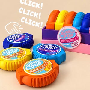 May include: A collection of colorful plastic Bubble Pop Bubble Roll fidget toys in orange, yellow, and blue. Each circular toy features a textured edge and a central label with the text Bubble Pop Bubble Roll. A pink display box holds several units.