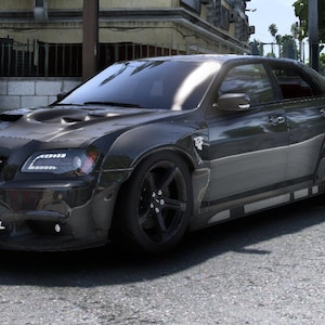 May include: A dark grey custom car with black wheels and a modified body kit. The car has a hood scoop, a black grille, and the word "DOLL" on the front bumper. The car is parked on an asphalt surface.