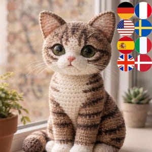 Puede incluir: Una figura de gato de ganchillo hecha a mano con rayas marrones y blancas, ojos verdes grandes y una nariz rosa. El gato está sentado erguido con las patas delanteras, mostrando un diseño detallado y texturizado. Es un artículo decorativo.