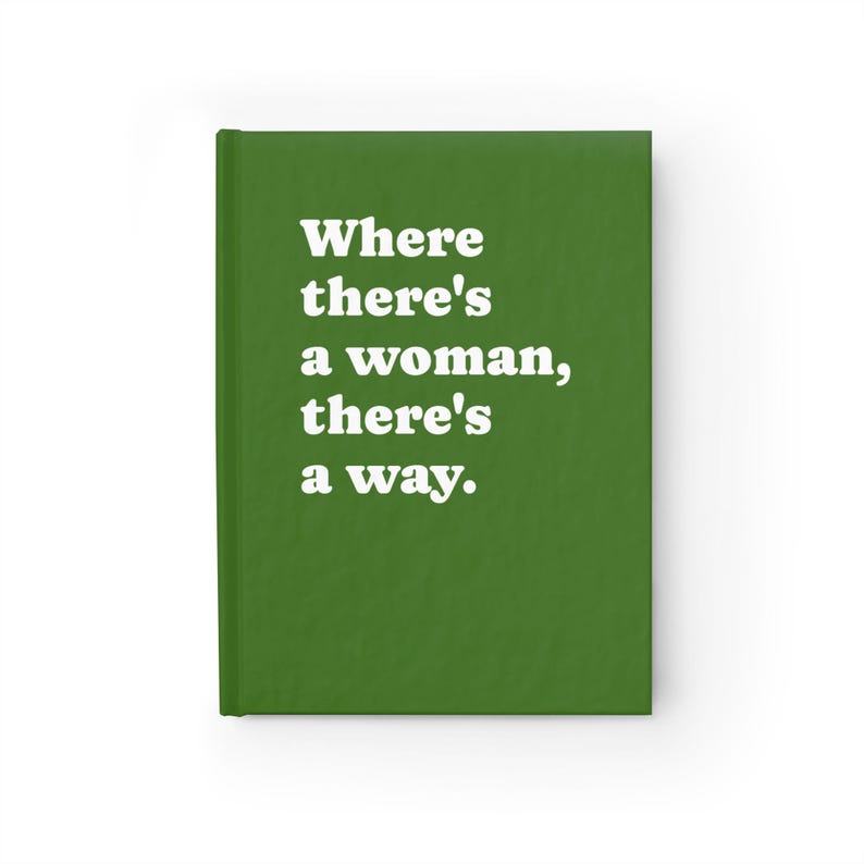 Op de afbeelding: Een groen notitieboek met harde kaft en de witte tekst Where there's a woman, there's a way. Het notitieboek heeft een effen groene kaft met een gladde textuur en een verticale rug aan de linkerkant, wat zorgt voor een strak ontwerp.