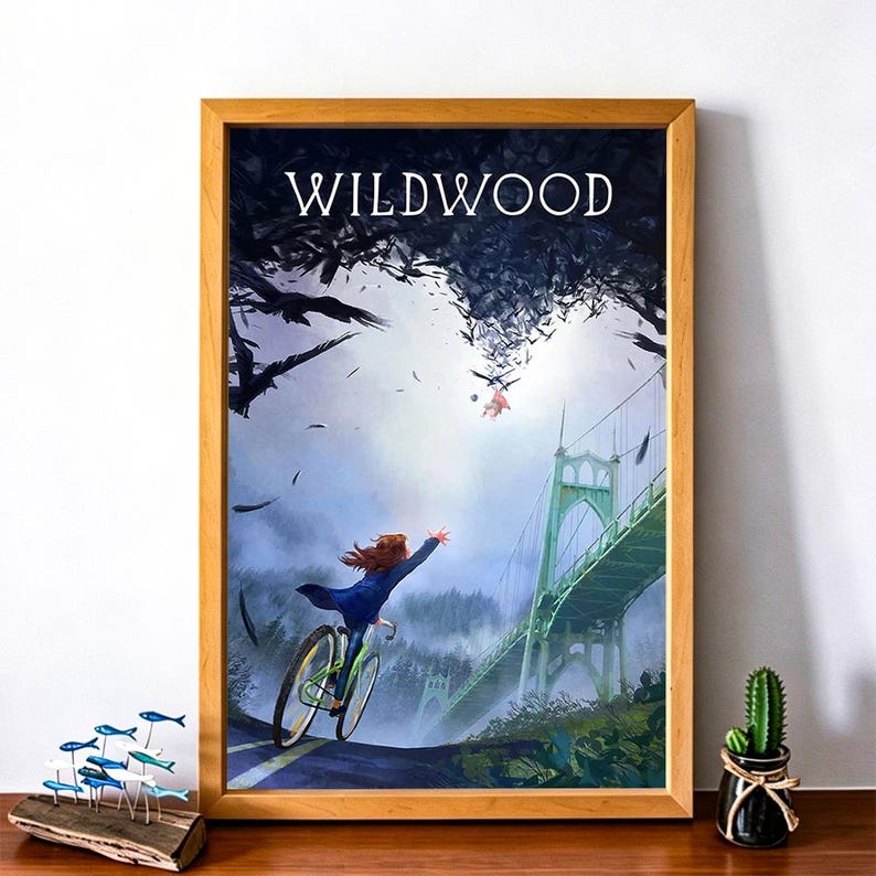 May include: A framed art print featuring a person on a bicycle reaching towards a figure in the sky, with a bridge in the background. The word "WILDWOOD" is at the top. The artwork is in a wooden frame.