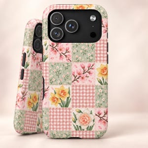May include: Two smartphone cases featuring a patchwork design of pink and white gingham squares, light green squares with small white flowers, and squares displaying illustrations of pink cherry blossoms and yellow daffodil flowers.